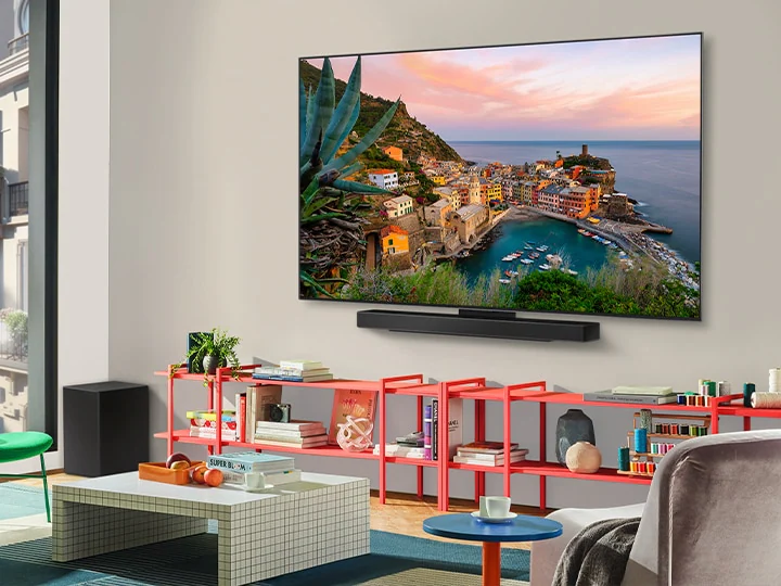 Гостиная внутри роскошного дома. Вид крепленного на стену телевизора LG OLED TV под углом. Можно видеть, что между телевизором и стеной нет щелей. 